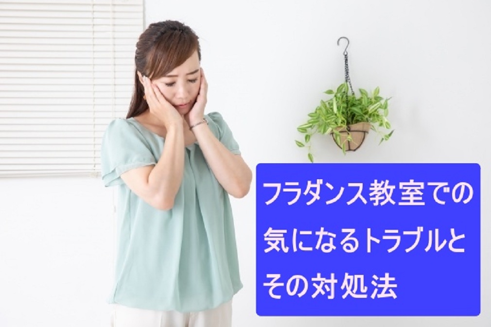 水色のブラウスを着た女性が両手で頬に手をやって悩んでいる